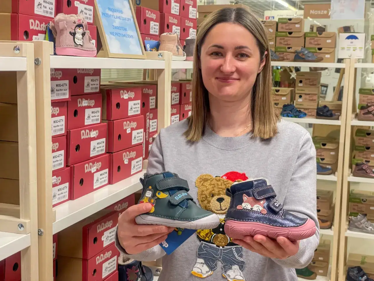 Rodzic przymierza buty dziecku w sklepie