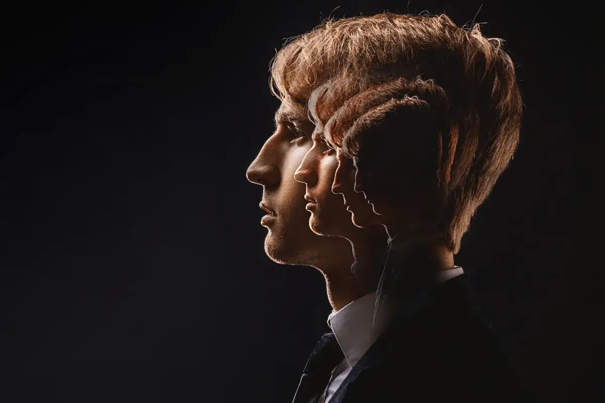 Profil mężczyzny w garniturze, z nałożonymi na siebie kolejnymi sylwetkami, tworzącymi efekt kontrakcji.