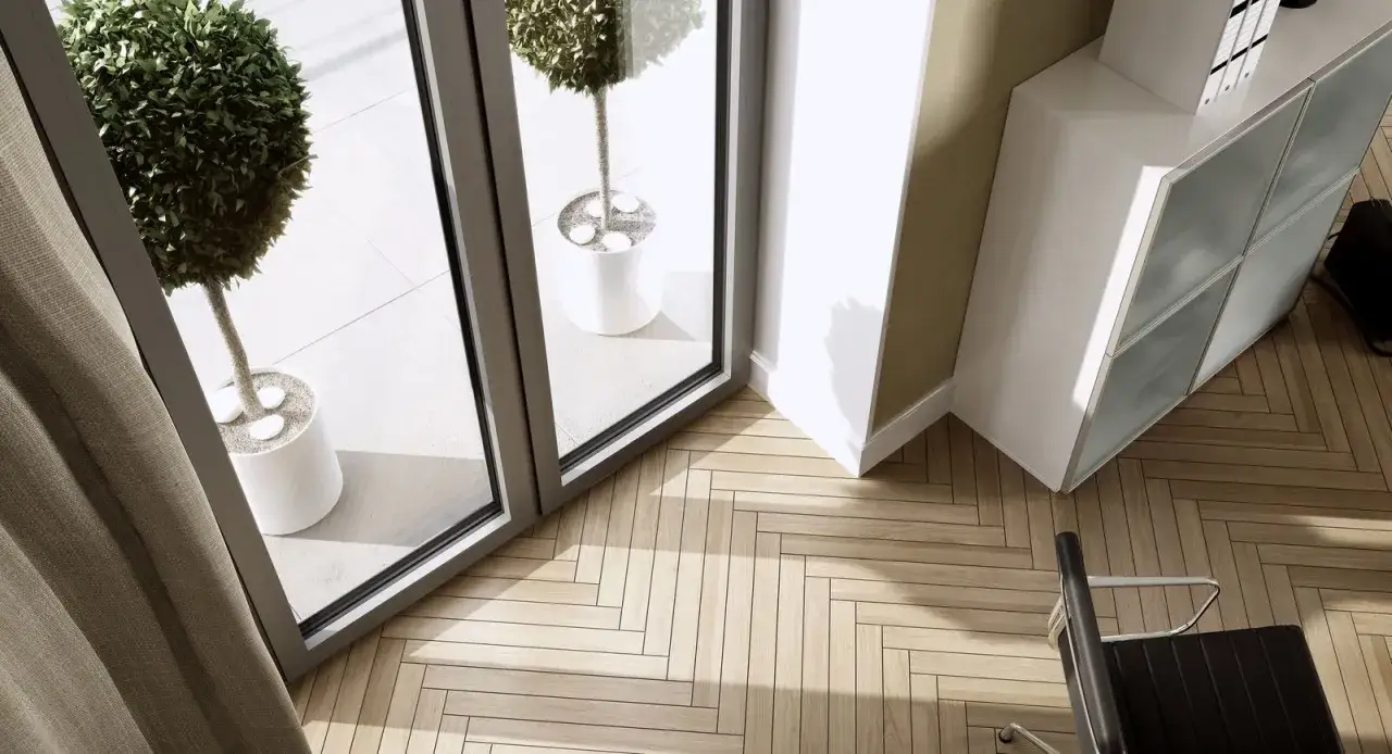 Nowoczesne rodzaje okien wpuszczają dużo światła na drewnianą podłogę. Widać też meble i rośliny.