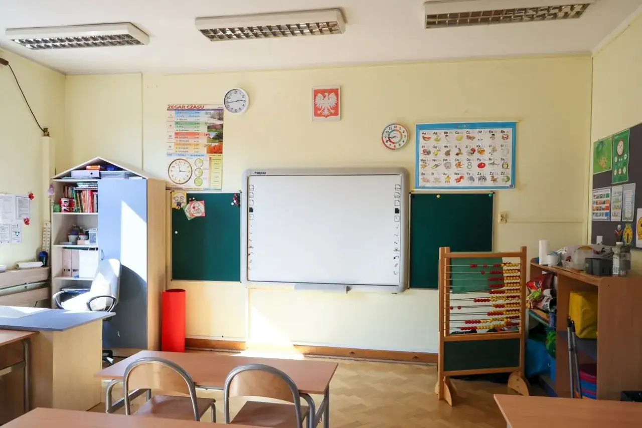 dziecko patrzące z niepewnością na tablicę w polskiej szkole