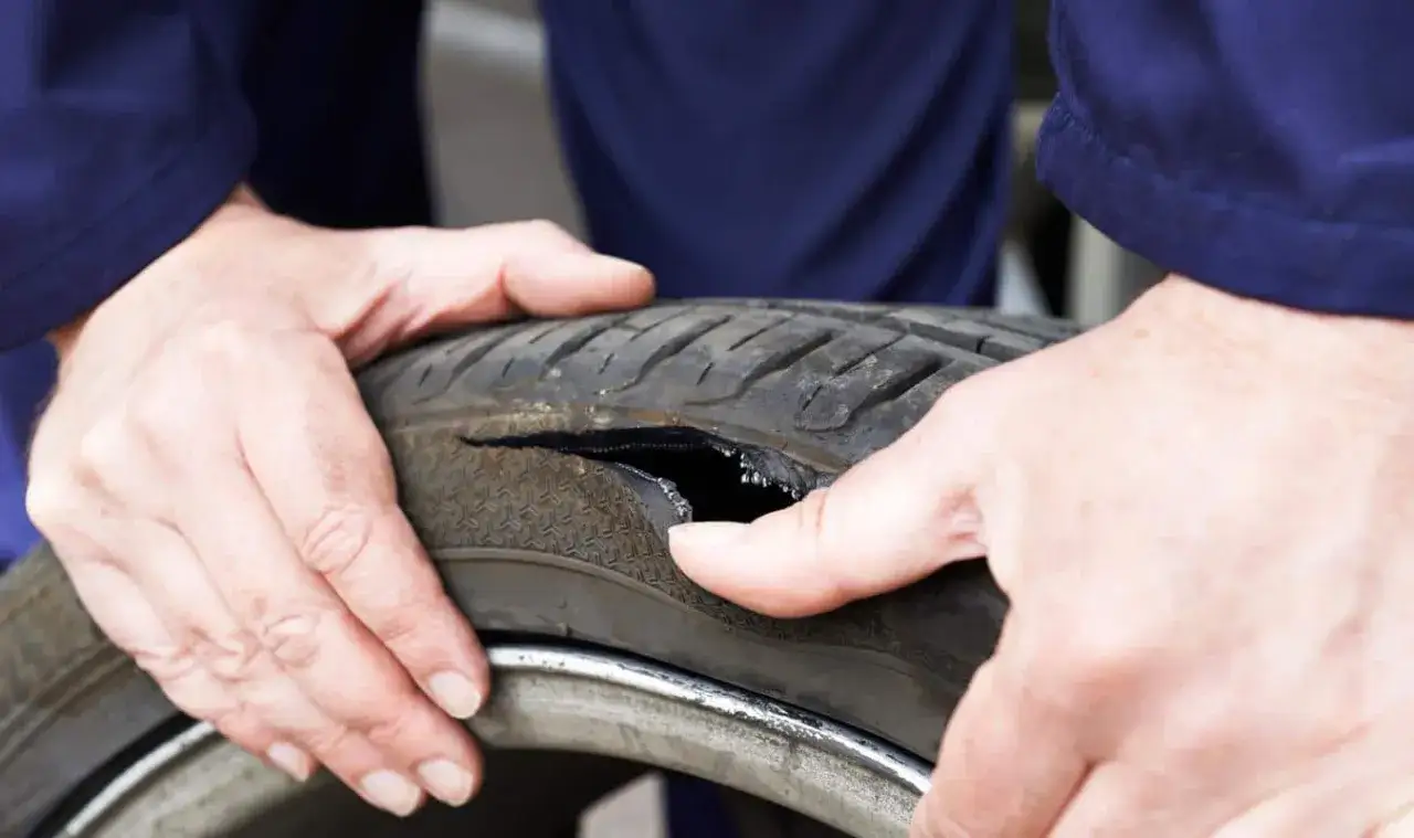 Uszkodzona opona, która wymaga wulkanizacji. Co to jest wulkanizacja? Naprawa uszkodzeń opon.