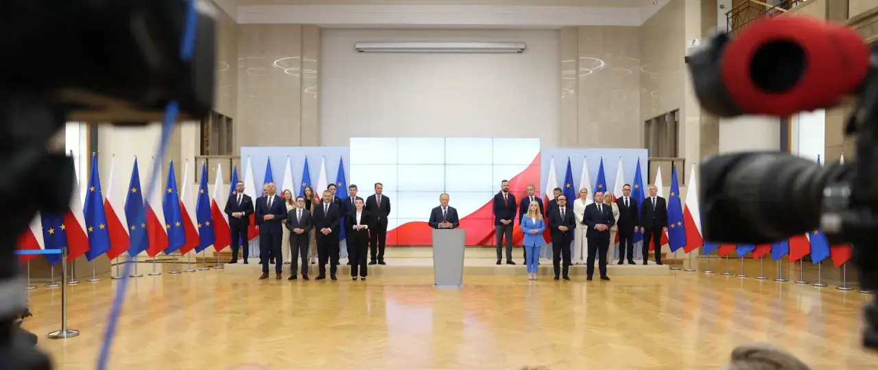 Uroczyste przedstawienie nowego składu rządu. W tle flagi Polski i Unii Europejskiej.