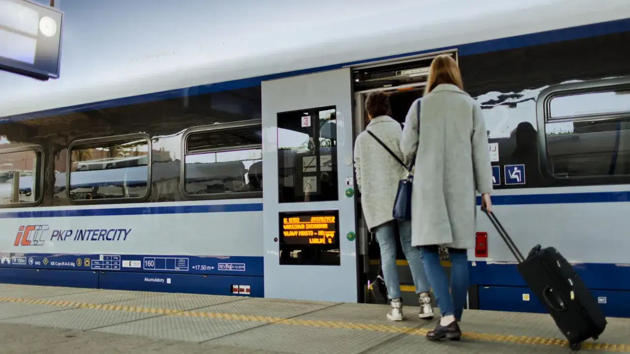 Dwie kobiety z walizką wsiadają do pociągu PKP Intercity. Może to być podróż z Warszawy do Wiednia.