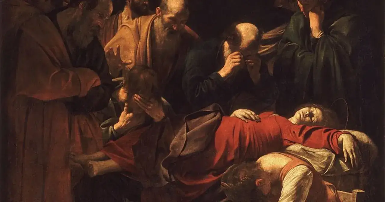 Grupa mężczyzn opłakuje martwą kobietę. Ich twarze wyrażają głęboki smutek, co doskonale oddaje, co oznacza 