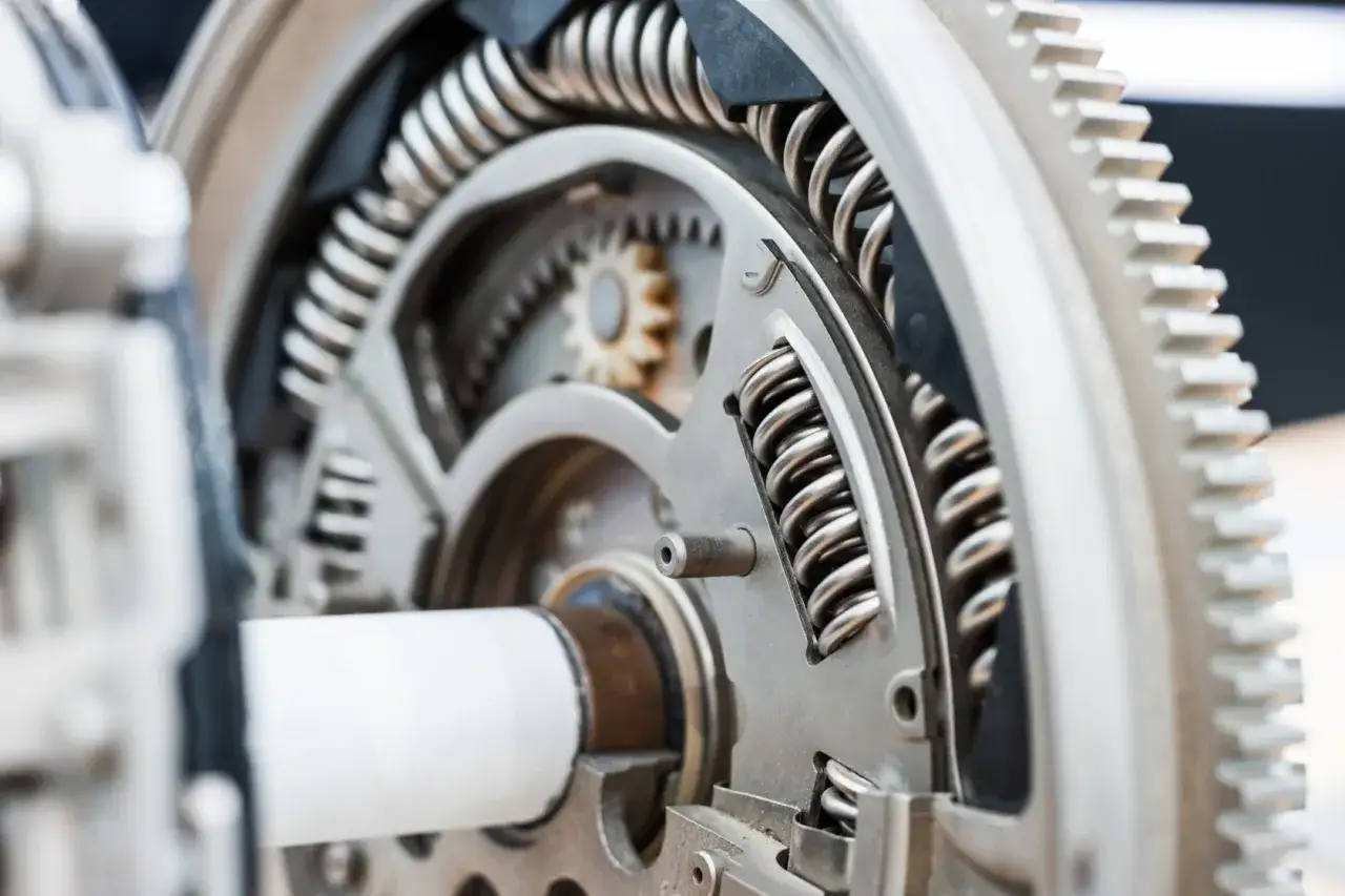 Sprężyny dwumasy w benzynie, gdy są uszkodzone, mogą powodować wibracje i stukanie. Widoczny mechanizm z zębatkami i sprężynami.