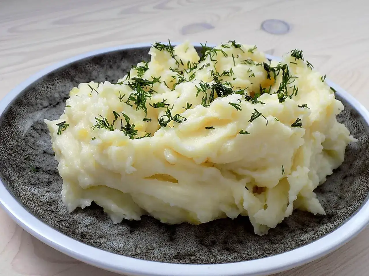 Puszyste puree ziemniaczane, posypane świeżym koperkiem. Idealne, gdy zastanawiasz się, ile gotować ziemniaki, by uzyskać taki efekt.