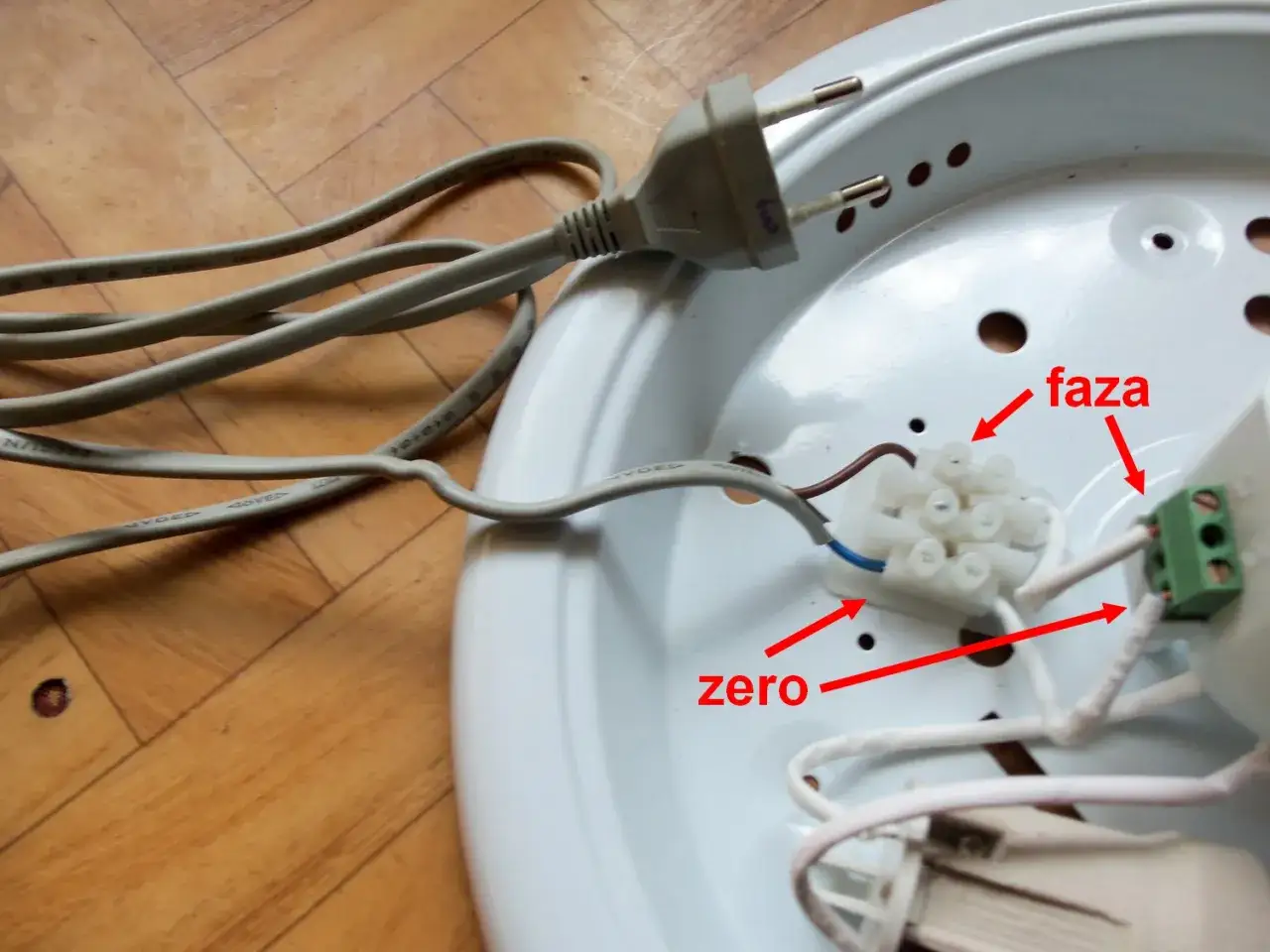 Lampa led z czujnikiem ruchu nie świeci. Widoczne przewody fazy i zera podłączone do złączki.