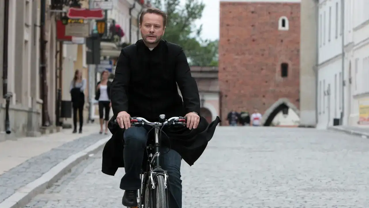 Artur Żmijewski jako Ojciec Mateusz pędzi rowerem przez Sandomierz, rozwiązując kolejne zagadki.