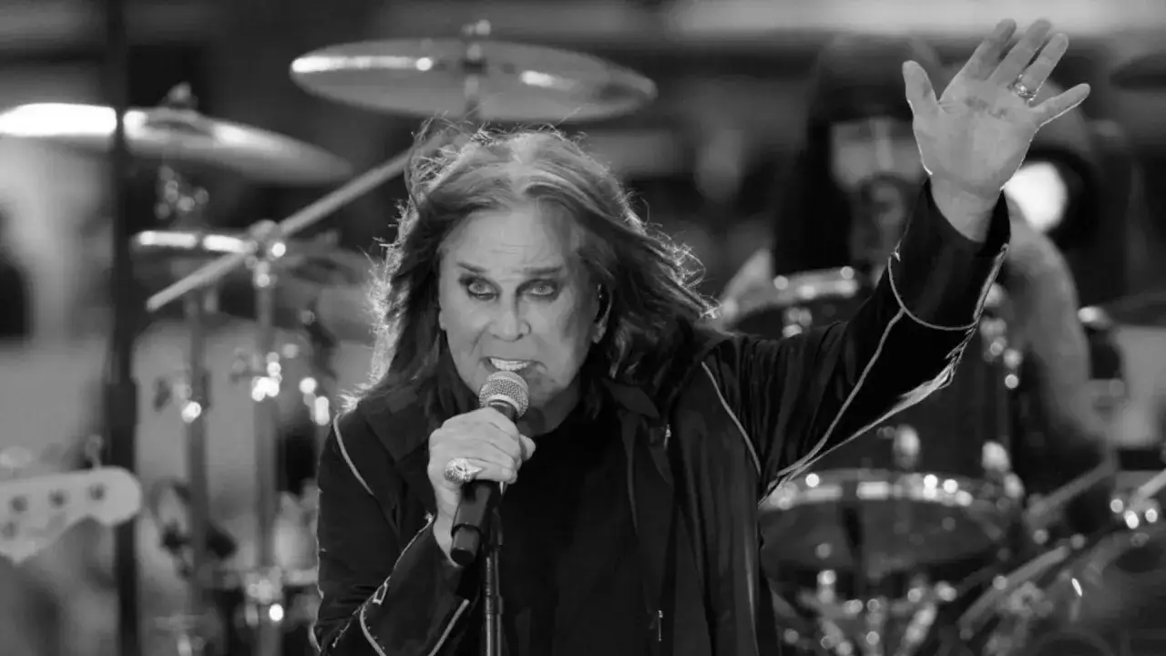 Ozzy Osbourne, jak zawsze w centrum uwagi, śpiewa do mikrofonu. W tle widać perkusję, a jego ręka uniesiona w geście, jakby witał nocnego nietoperza.