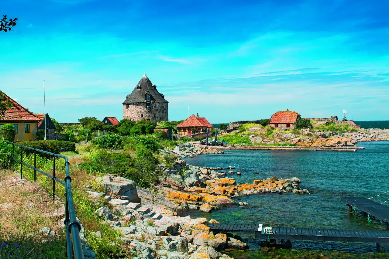 Kamienna wieża i domki na skalistej duńskiej wyspie na Bałtyku.