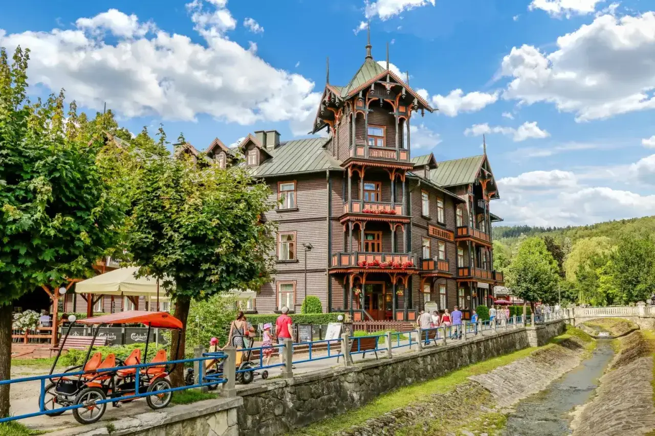 Drewniany pensjonat w Krynicy Zdroju, z charakterystyczną architekturą, zachęca do spacerów i odkrywania urokliwych krynica zdrój atrakcje.