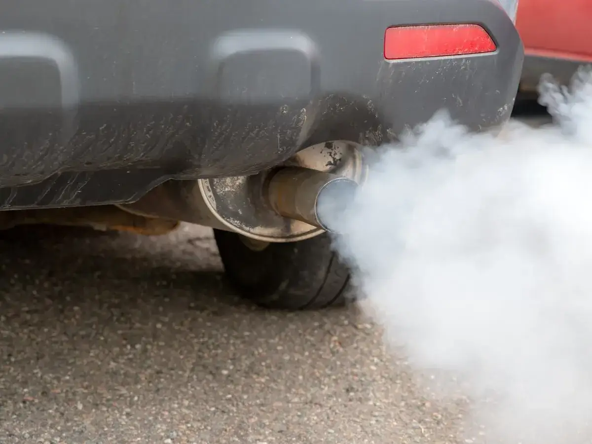 Z rury wydechowej wydobywa się gęsty, biały dym, świadczący o pracy silnika.