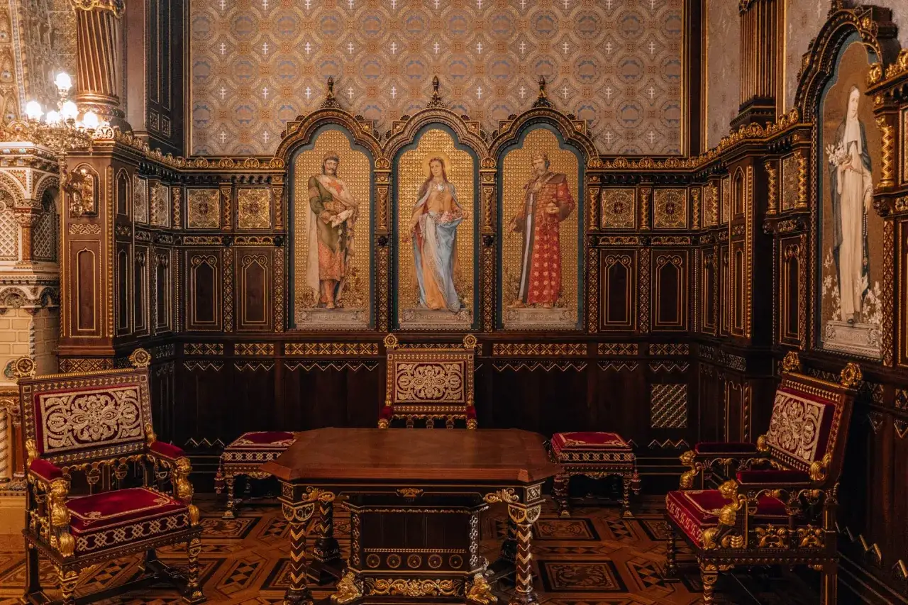 Bogato zdobione wnętrze, być może w Muzeum Sztuk Pięknych w Budapeszcie, z tronami i malowidłami.