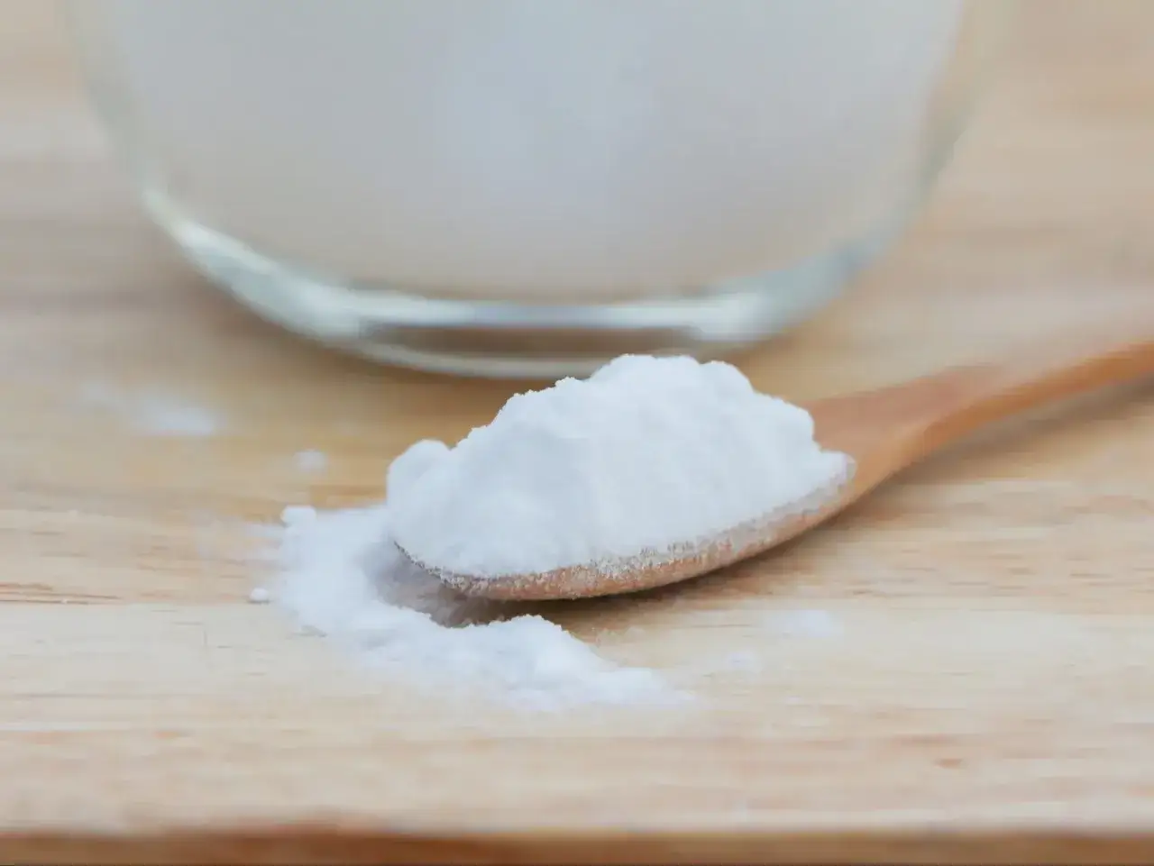 Łyżka z białym proszkiem, który może pomóc na zgagę. Soda oczyszczona w zasięgu ręki.