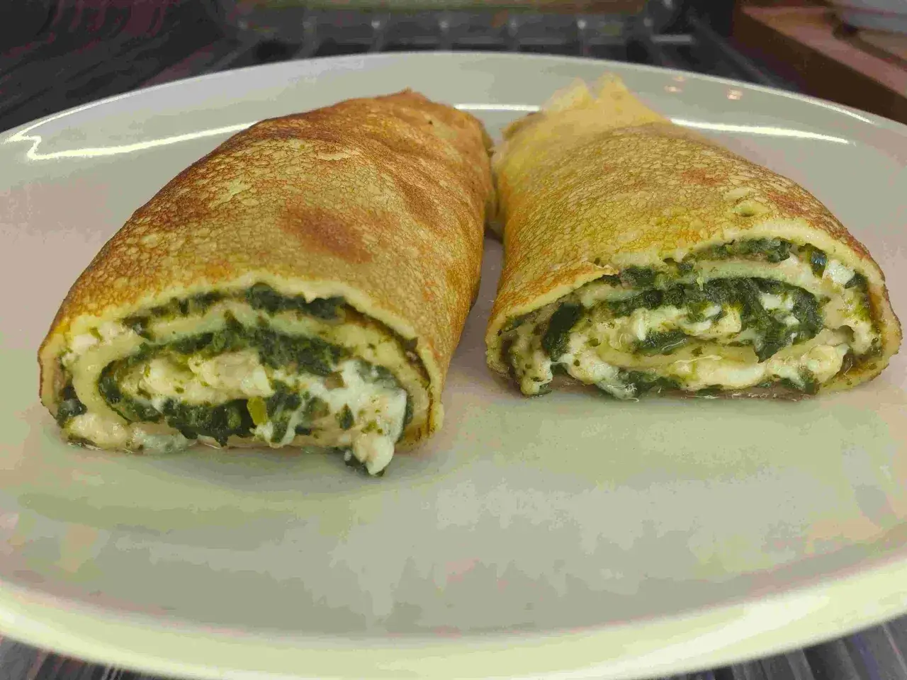 Dwa naleśniki z serem i szpinakiem, idealne na obiad.