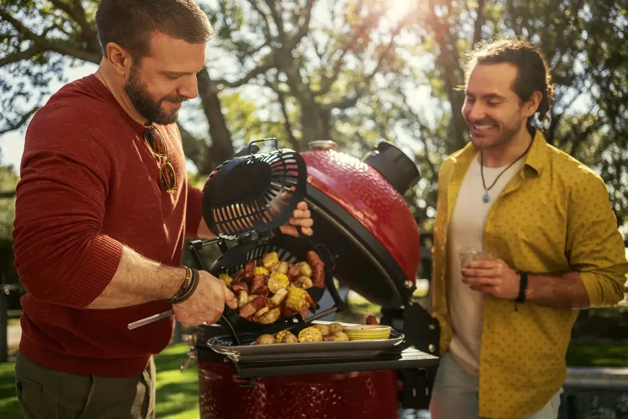 Dwóch mężczyzn cieszy się letnim popołudniem przy grillu na drzewo, przygotowując pyszne jedzenie.