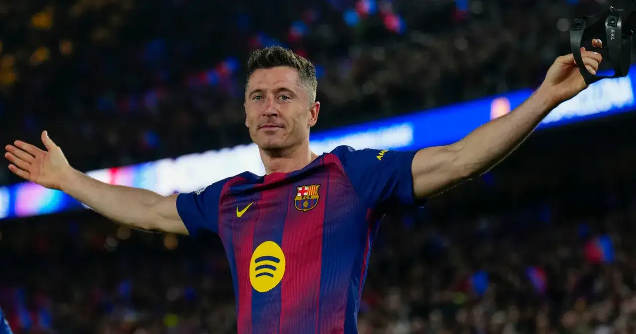 Robert Lewandowski w koszulce FC Barcelony, który rozegrał najwięcej meczów w Lidze Mistrzów, pozdrawia kibiców.