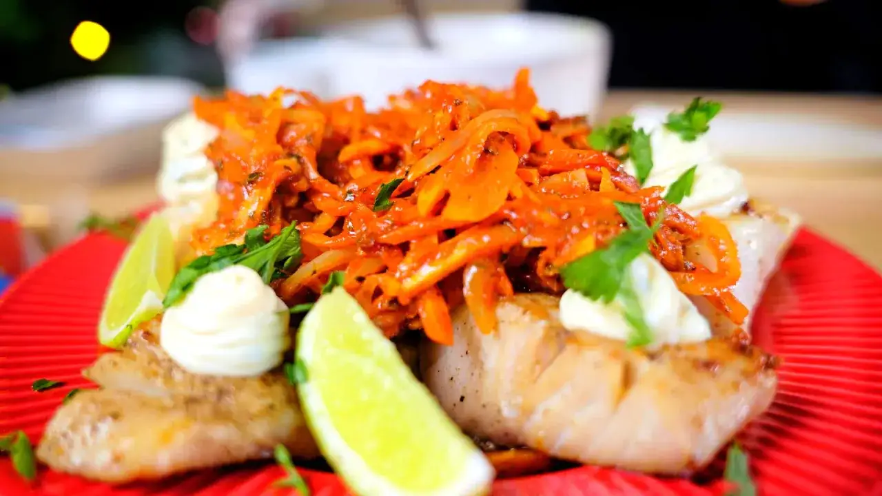 ryba po grecku na talerzu z cytryną i natką pietruszki