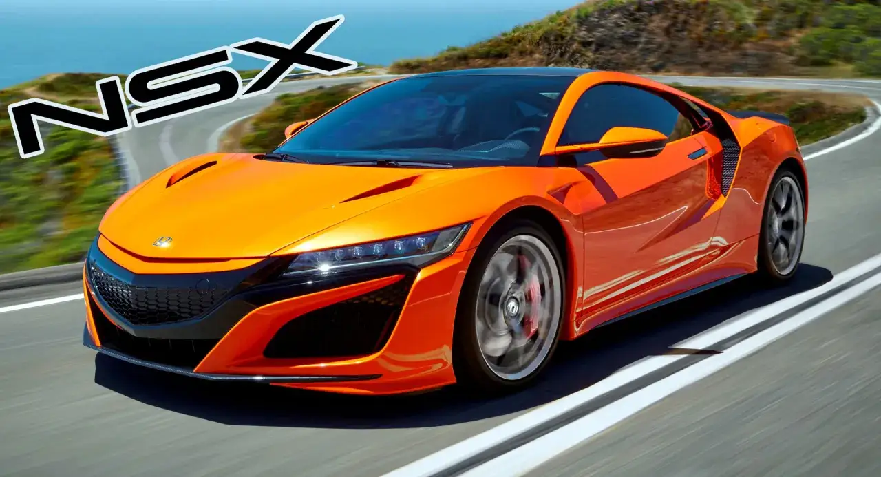 Pomarańczowy Honda NSX pędzi po krętej drodze z widokiem na ocean.