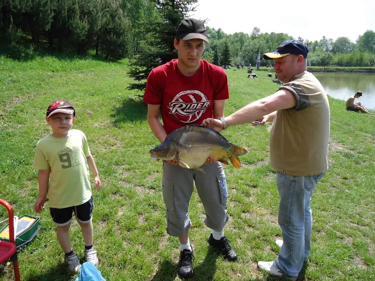 Chłopcy z rybą nad jeziorem, idealne miejsce gdzie na ryby bez karty Kraków.