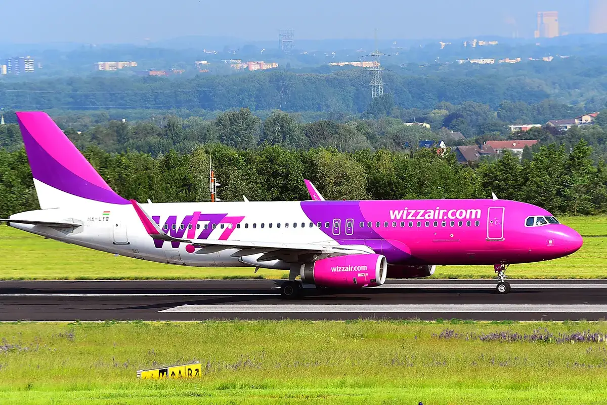 Różowy samolot Wizz Air na pasie startowym. Idealny na tanie loty Kraków.
