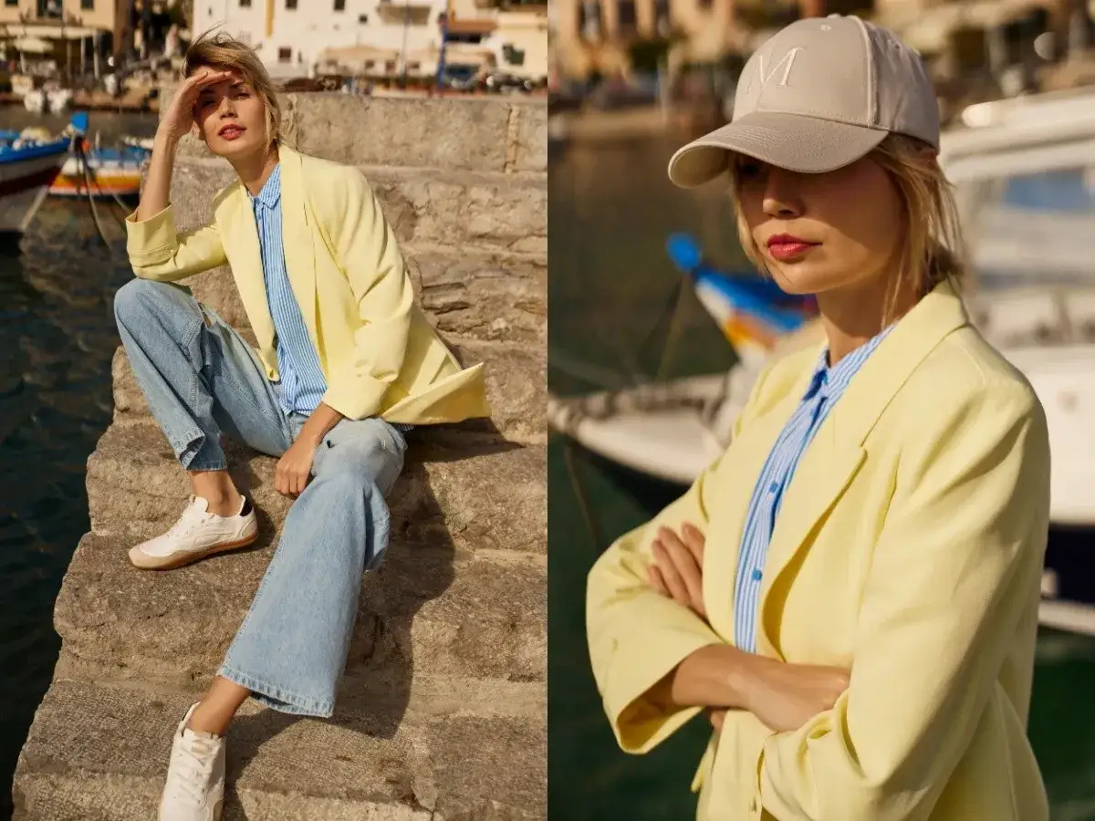 Kobieta w żółtej marynarce i jeansach prezentuje letnie stylizacje nad wodą. Luźny, miejski look.