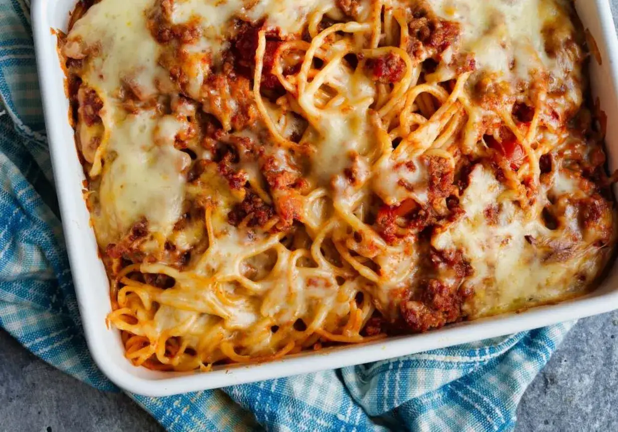 Pyszne spaghetti z piekarnika, zapieczone pod warstwą ciągnącego się sera i sosu bolońskiego. Idealne na rodzinny obiad.