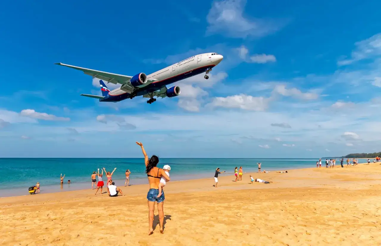 Samolot Aeroflot zbliża się do plaży, gdzie ludzie odpoczywają. Zastanawiasz się, ile trwa lot do Albanii z Warszawy?