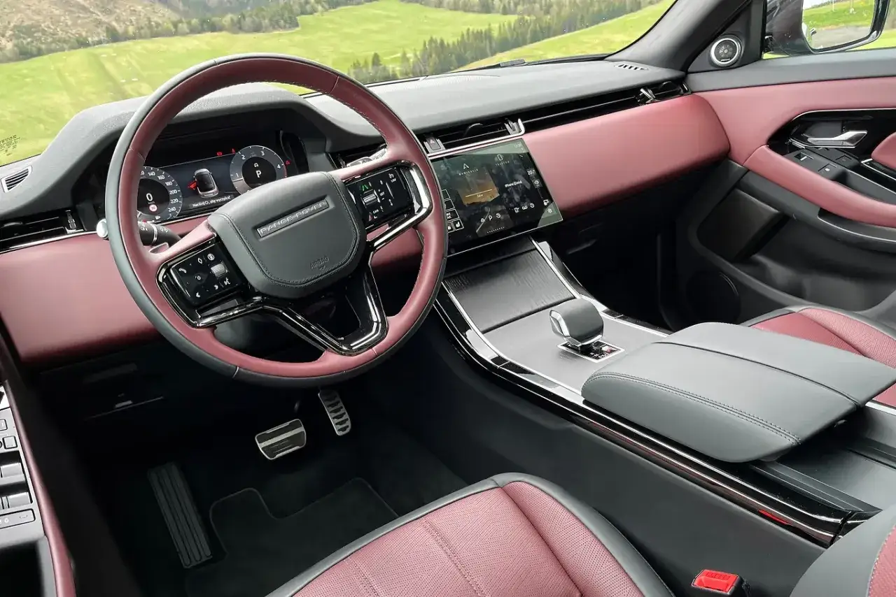 Wnętrze Land Rover Evoque z bordową tapicerką i nowoczesnym panelem.