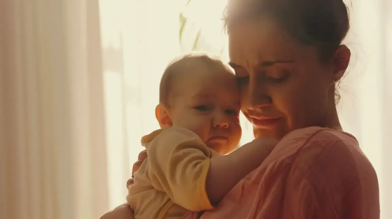 Czuła matka tuli dziecko, martwiąc się o jego zdrowie. Nystatyna dla dzieci może pom&oacute;c w walce z infekcjami.