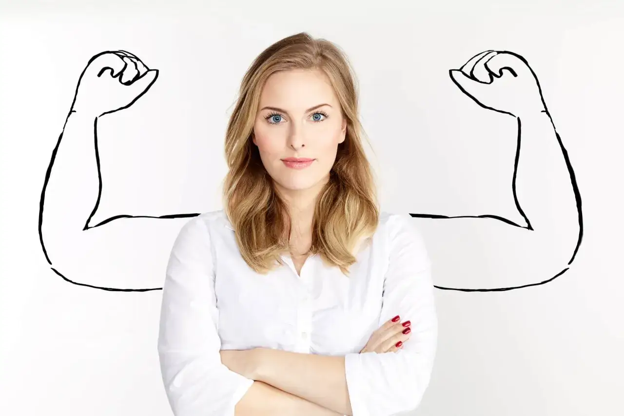 Kobieta z pewnością siebie, z ramionami jak u siłacza, symbolizująca akceptację siebie.