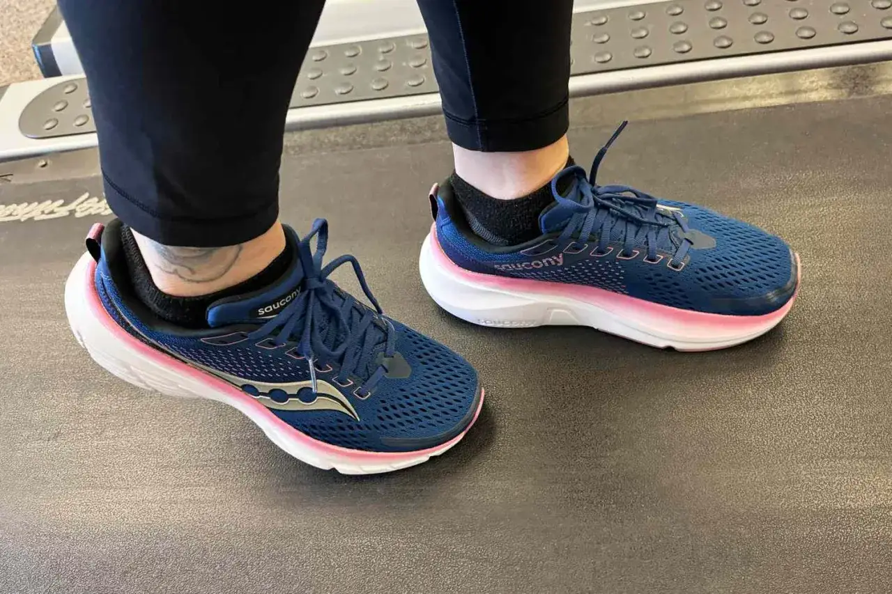Granatowe buty do maratonu Saucony z różowymi akcentami na podeszwie, gotowe na trening na bieżni.