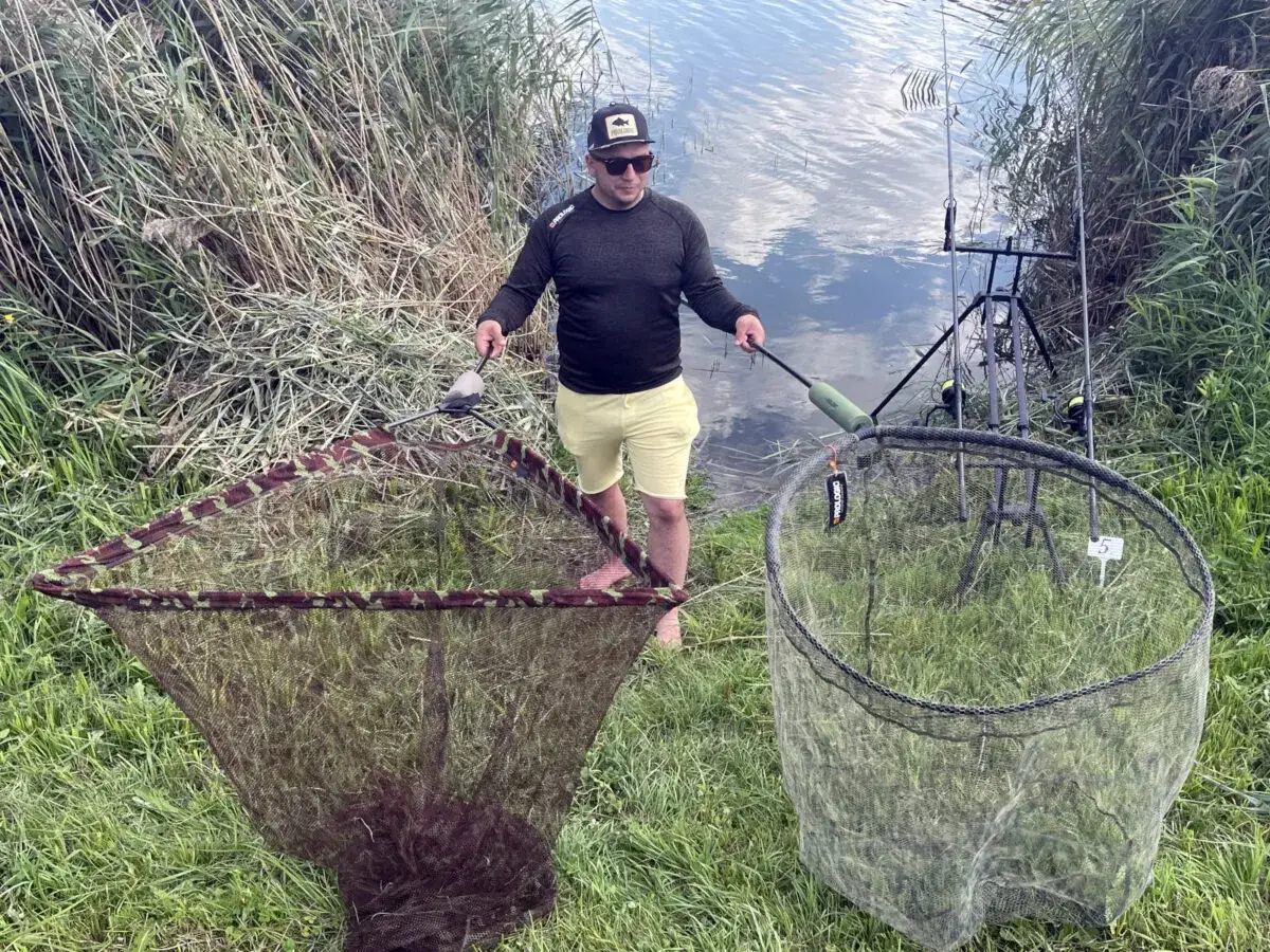 Wędkarz z matą i podbierakiem na łowisku