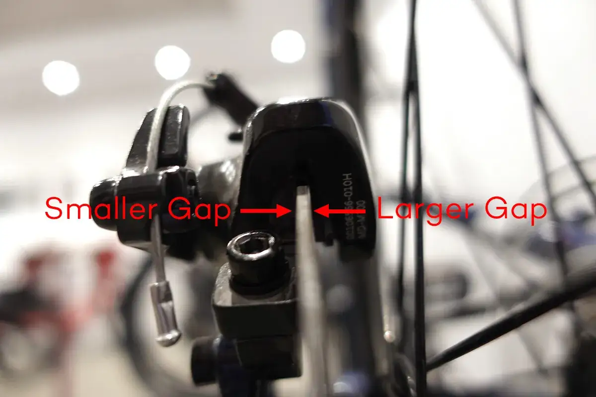 Regulacja hamulców hydraulicznych w rowerze: mniejsza i większa szczelina między klockiem a tarczą.