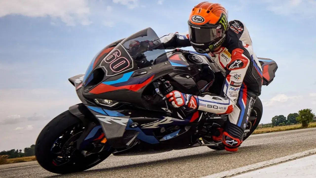 Wyścigowy motocykl BMW z numerem 60, prowadzony przez zawodnika w kasku i kombinezonie, pędzi po torze. To prawdopodobnie najdroższy motor na świecie.