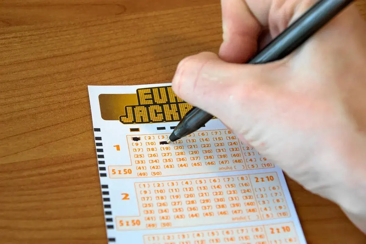Ręka zaznacza liczby na kuponie Eurojackpot. Zastanawiasz się, ile czasu na odebranie wygranej w Eurojackpot?