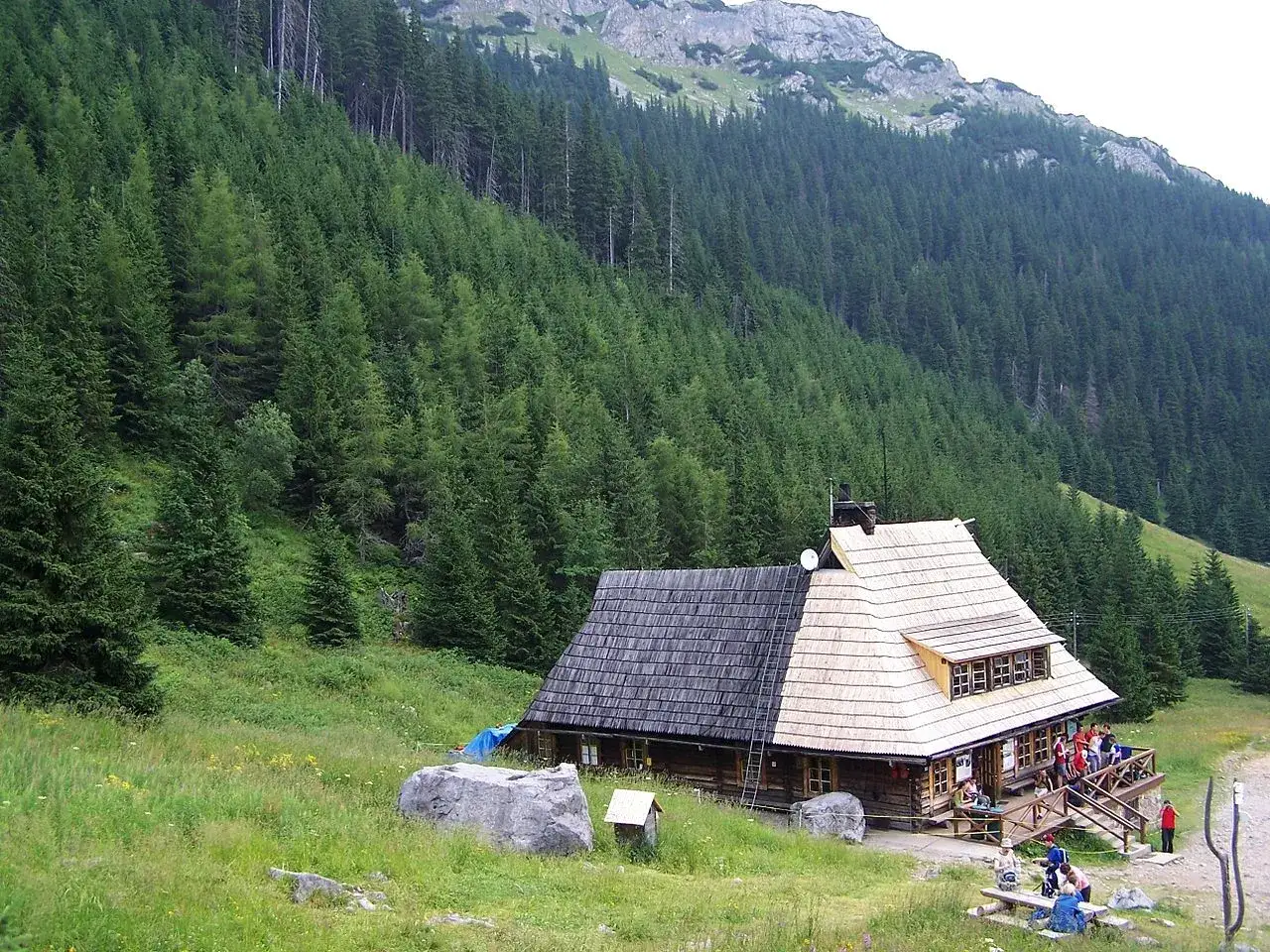 Drewniane schronisko w Tatrach, otoczone lasem. Zastanawiasz się, ile kosztuje noc w schronisku w Tatrach?