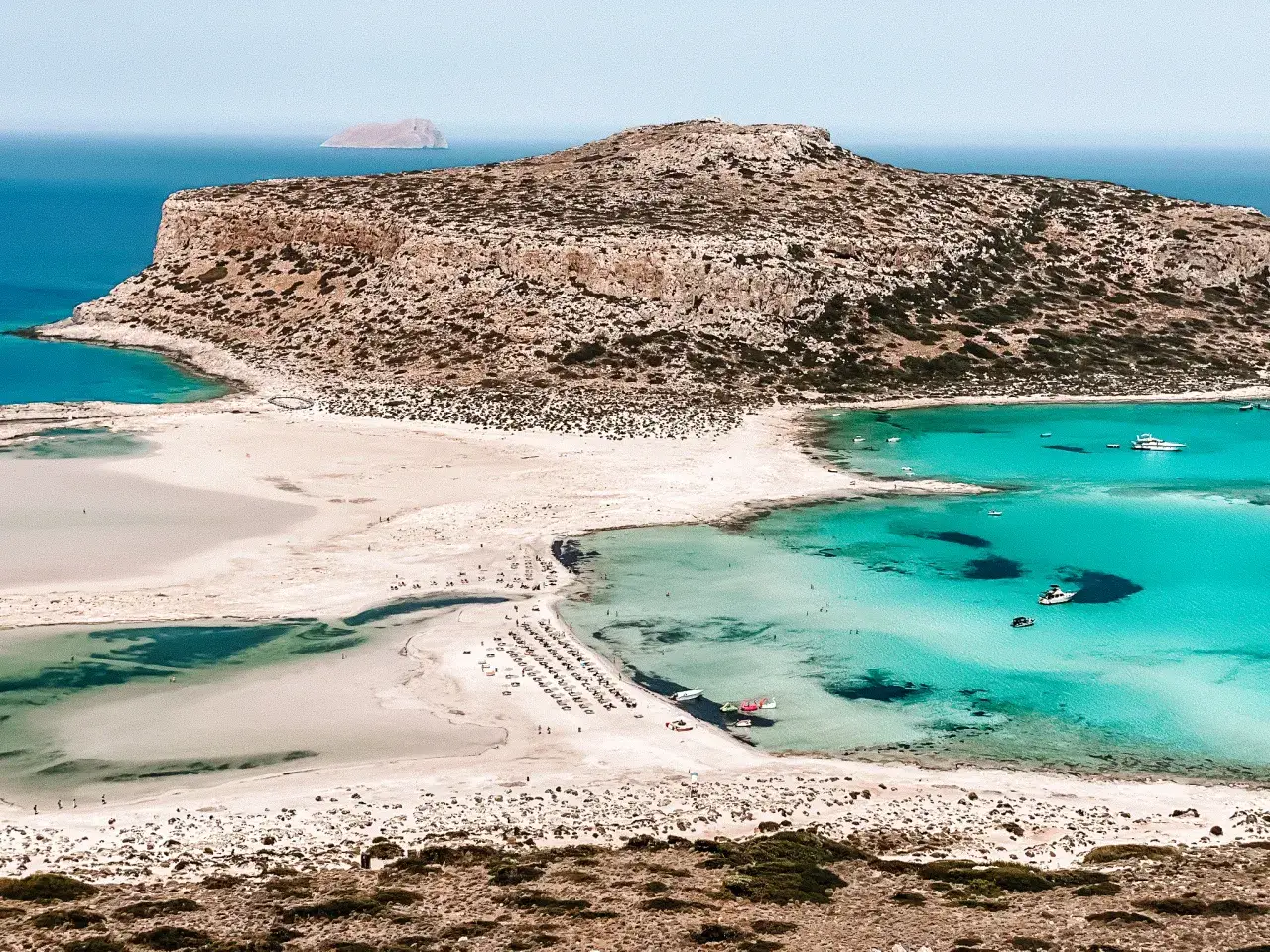 Rajskie plaże na Krecie: turkusowa woda, piaszczyste wybrzeże i skaliste wzgórza tworzą idylliczny krajobraz.