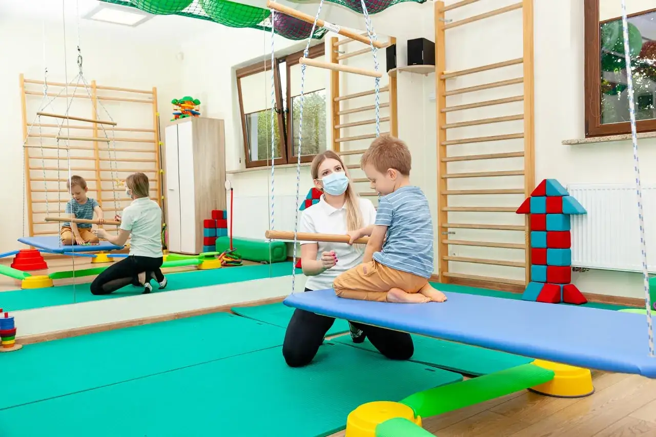 Terapeuta SI pracujący z dzieckiem w sali sensorycznej