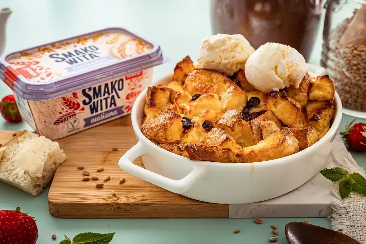 Pudding chlebowy z rodzynkami i lodami, obok masło 