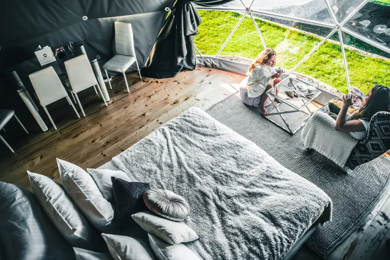 Wygodny glamping w Bukowinie Tatrzańskiej. Dwie kobiety relaksują się w namiocie z widokiem na zieleń.