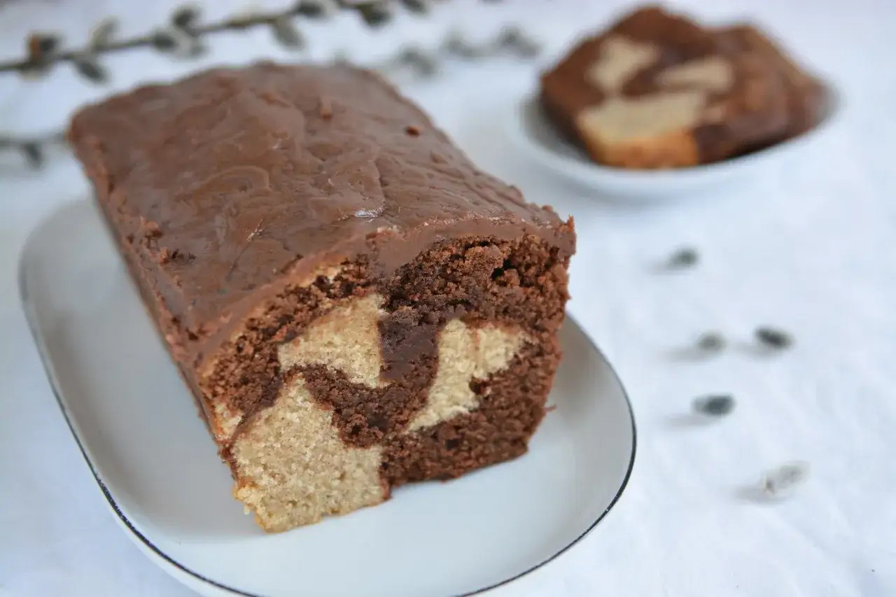 Wilgotna babka marmurkowa na oleju, z czekoladową polewą, prezentuje się apetycznie.