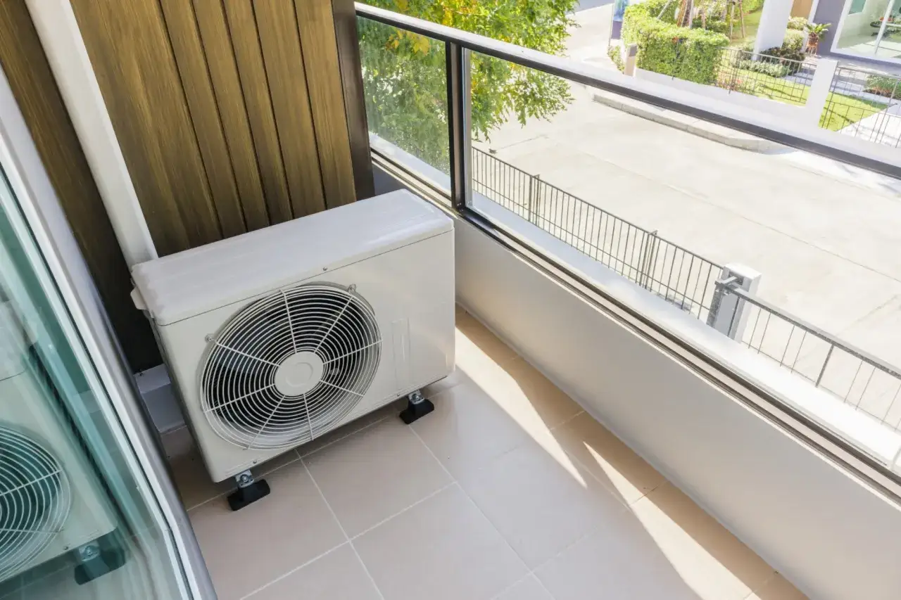 Jednostka zewnętrzna klimatyzacji w mieszkaniu na balkonie, zapewniająca komfort w upalne dni.
