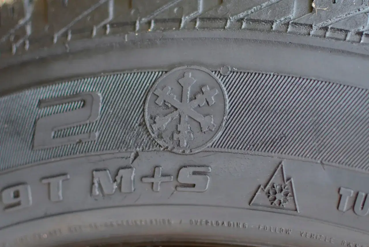 Opona wielosezonowa z oznaczeniem M+S i symbolem płatka śniegu w górach. Tak rozpoznać opony wielosezonowe.