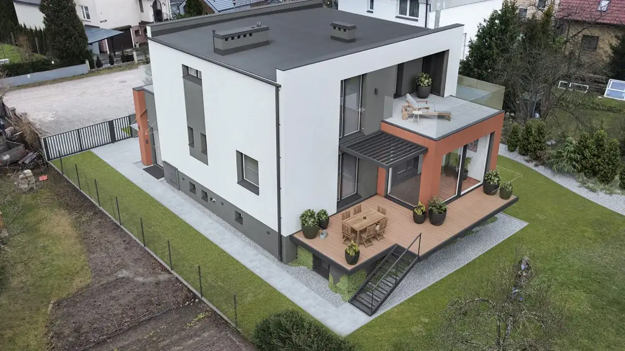 Nowoczesny dom kostka z tarasem i ogrodem. Widać metamorfozę działki, gdzie powstał piękny dom kostka.