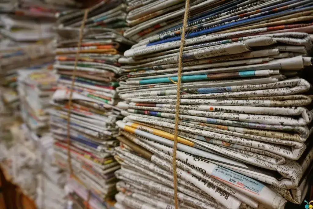 kolekcja starych gazet i książek reporterskich na p&oacute;łce