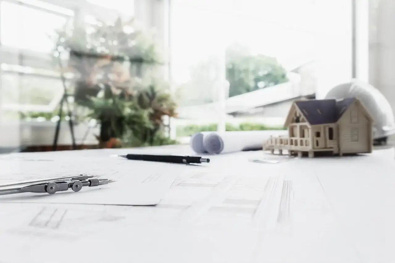 Plany architektoniczne, makietka domu i cyrkiel. To wszystko potrzebne, by stworzyć lokal stanowiący odrębną nieruchomość.