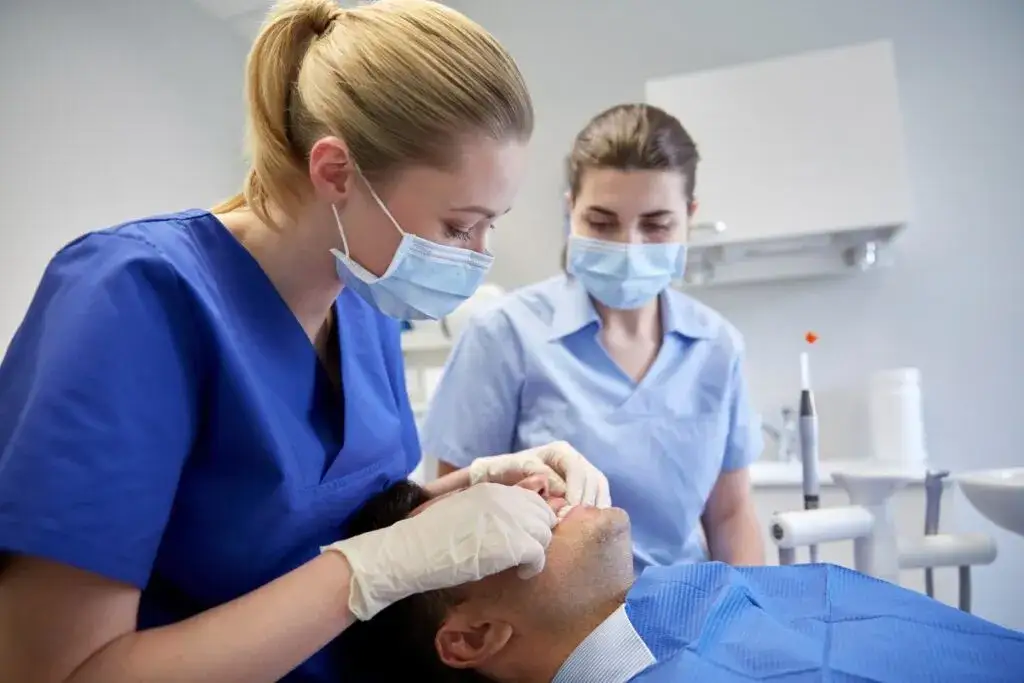dentysta bada pacjenta diagnostyka b&oacute;lu zęba
