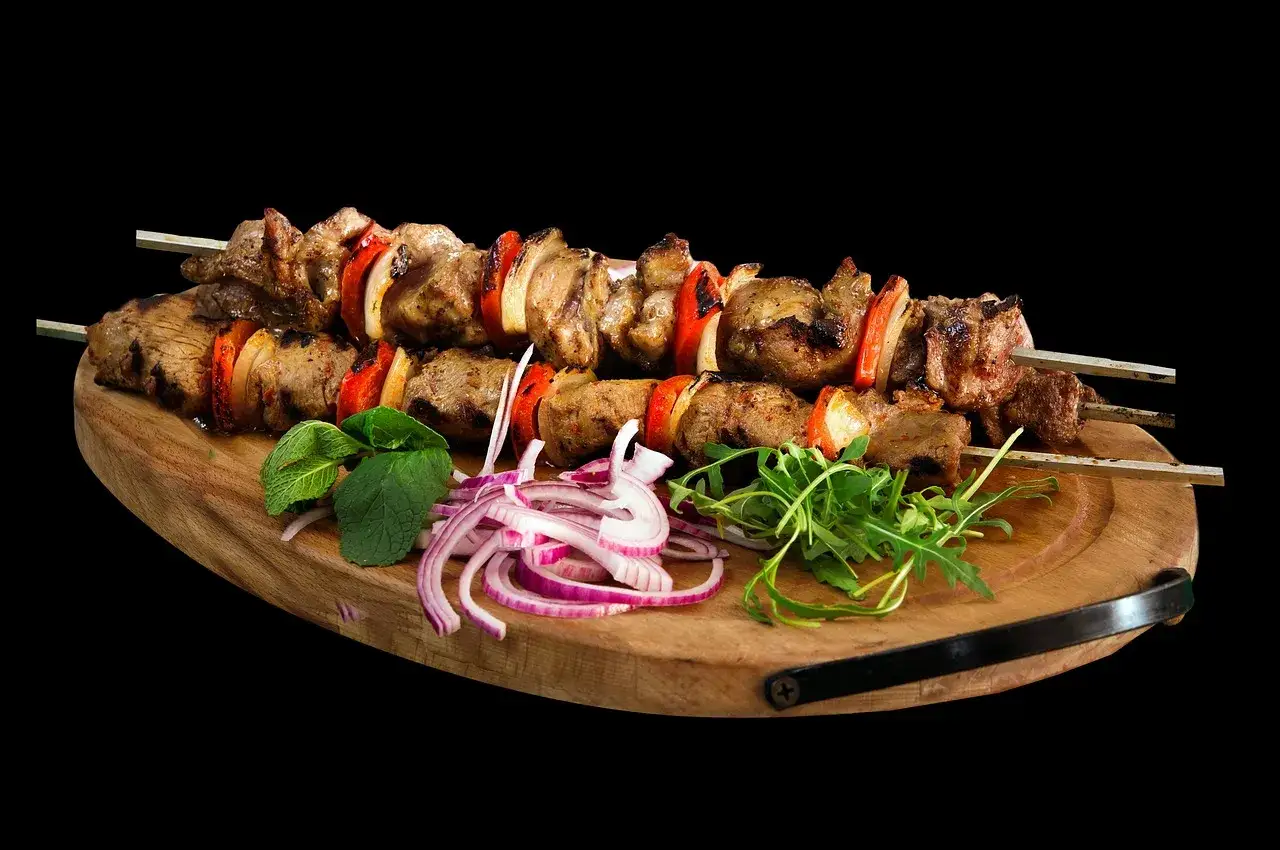 Szukając odpowiedzi na pytanie, skąd pochodzi kebab, warto spojrzeć na te soczyste szaszłyki z mięsa i warzyw, podane z cebulą i rukolą.