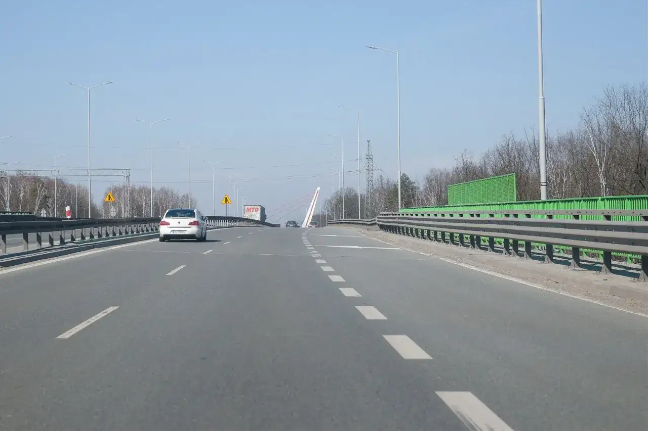 Droga w kierunku Katowic, z widocznym mostem i znakami ostrzegawczymi. Informacje drogowe Katowice.